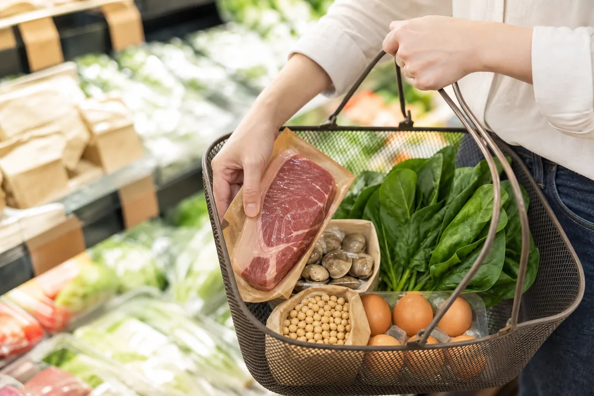 牛肉やあさり、ほうれん草など鉄を含む食品を買い物かごに入れる様子