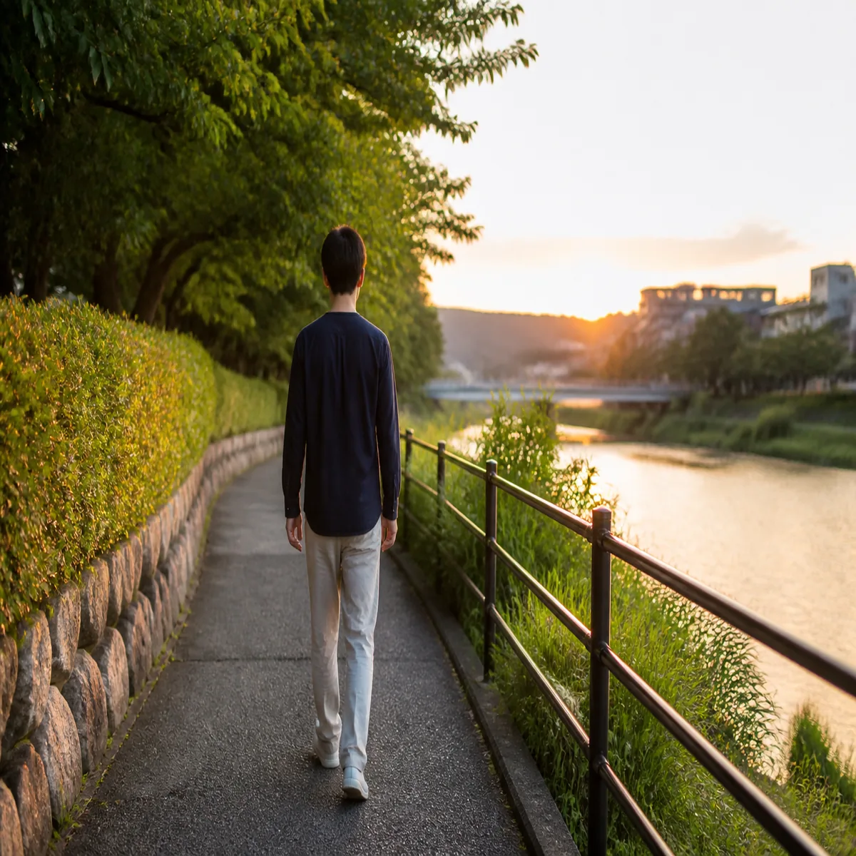 夕方の川沿いをゆっくり歩く人